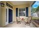 Small front porch with two wicker chairs and a small table at 1655 Lancashire Dr # 1655, Venice, FL 34293