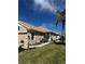 Tan one-story house with tile roof, palm trees, and manicured lawn at 1807 San Trovaso Way, Venice, FL 34285