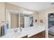 Clean bathroom with double vanity, large mirror, and access to bedroom at 19155 Mangieri St, Venice, FL 34293