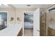Bathroom with double vanity, large mirror, and access to bedroom and shower at 19155 Mangieri St, Venice, FL 34293