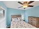 Light and airy bedroom featuring a ceiling fan and dresser at 19155 Mangieri St, Venice, FL 34293