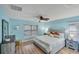 Spacious bedroom with light blue walls, king-size bed, and ceiling fan at 19155 Mangieri St, Venice, FL 34293