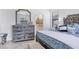 Main bedroom with rustic wood dresser and blue bedding at 1932 W Isles Rd, Port Charlotte, FL 33953