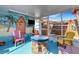 Fun screened porch with beach mural, colorful chairs, and fire pit at 1985 Fairview Dr, Englewood, FL 34223
