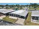 Aerial view of a single-wide mobile home with carport, situated in a waterfront community at 199 Palm Air Dr, Osprey, FL 34229