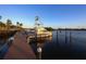 Serene view of a boat at a dock on calm water, beautiful sunset colors at 199 Palm Air Dr, Osprey, FL 34229
