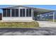Front view of a move-in ready mobile home with covered parking and a screened porch at 199 Palm Air Dr, Osprey, FL 34229