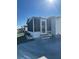 Side view of a white single-wide manufactured home with screened porch at 199 Palm Air Dr, Osprey, FL 34229