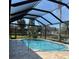 Inviting screened-in pool with brick paver deck overlooking the beautifully landscaped backyard and pond at 20 Saint Croix Way, Englewood, FL 34223