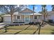 Tan house with teal front door, white porch, and landscaped yard at 205 Tortuga Dr, Nokomis, FL 34275