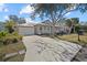 Tan house with white garage door, teal front door, and a covered porch at 205 Tortuga Dr, Nokomis, FL 34275
