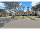 Tan house with teal front door, white porch railings, and mature landscaping at 205 Tortuga Dr, Nokomis, FL 34275