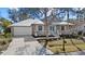 Tan house with white garage and teal front door, nicely landscaped at 205 Tortuga Dr, Nokomis, FL 34275