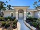 Front entrance with arched doorway and manicured landscaping at 2111 Tocobaga Ln, Nokomis, FL 34275