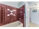 Bathroom with burgundy tile and a tub at 221 Firenze W Ave, Venice, FL 34285