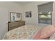 Bright bedroom with floral bedding, dresser, and window coverings at 23210 Banbury Way # 101, Venice, FL 34293