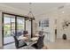 Bright dining area with glass table, four chairs, and view to patio at 23210 Banbury Way # 101, Venice, FL 34293