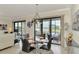 Modern dining room with glass table and lake view at 23210 Banbury Way # 101, Venice, FL 34293
