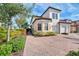 Exterior view of a two-story townhome with a brick driveway and landscaping at 23210 Banbury Way # 101, Venice, FL 34293