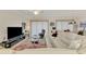 Living room with sectional sofa and large TV at 23210 Banbury Way # 101, Venice, FL 34293
