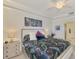 Main bedroom with king-size bed, ensuite bathroom access, and ceiling fan at 23210 Banbury Way # 101, Venice, FL 34293