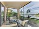 Relaxing screened lanai overlooking a lake with comfortable seating at 23210 Banbury Way # 101, Venice, FL 34293