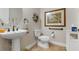 Guest bathroom with pedestal sink, toilet and decorative artwork at 23402 Copperleaf Dr, Venice, FL 34293