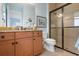 Bathroom with wood cabinets, granite countertop, and large walk-in shower at 23402 Copperleaf Dr, Venice, FL 34293