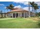 Mediterranean-style clubhouse with lawn and palm trees at 23402 Copperleaf Dr, Venice, FL 34293