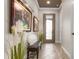 Elegant entryway with tiled floor, bench, and decorative artwork at 23402 Copperleaf Dr, Venice, FL 34293