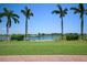 Scenic view of a lush golf course with palm trees and a lake at 23402 Copperleaf Dr, Venice, FL 34293