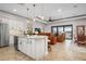 Modern kitchen with white cabinets, granite island, and open layout to living area at 23402 Copperleaf Dr, Venice, FL 34293