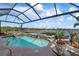 Inviting pool area with spa, covered lanai, and lake view at 23402 Copperleaf Dr, Venice, FL 34293