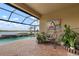 Relaxing pool area with covered patio, hanging chair, and lake view at 23402 Copperleaf Dr, Venice, FL 34293