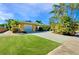 Charming single story home with a large grassy yard, driveway, and lush landscaping at 237 San Marco Dr, Venice, FL 34285