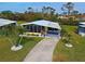 Mobile home with driveway and surrounding landscape at 3022 Audubon Ave, Englewood, FL 34224