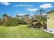 Spacious backyard with lush landscaping and mature trees at 3022 Audubon Ave, Englewood, FL 34224