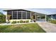 Yellow mobile home with covered porch, landscaped yard, and driveway at 3022 Audubon Ave, Englewood, FL 34224