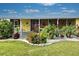 Yellow mobile home with landscaped yard and tropical plants at 3022 Audubon Ave, Englewood, FL 34224