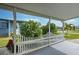 Covered front porch with white picket fence and lush landscaping at 3022 Audubon Ave, Englewood, FL 34224