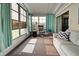Bright sunroom with light teal curtains, sofa, and rocking chair at 3022 Audubon Ave, Englewood, FL 34224