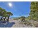 Scenic beach access with a wooden bench under palm trees at 335 Englewood Isles Pkwy # 55, Englewood, FL 34223