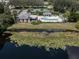 Aerial view of a community pool, tennis courts, clubhouse, and pond at 335 Sunset Lake Blvd, Venice, FL 34292