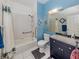 Bathroom with a shower, a large mirror, blue accent walls, and tiled floors at 335 Sunset Lake Blvd, Venice, FL 34292