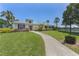 The community clubhouse has a circular window, well manicured landscaping, and a sidewalk leading to the entrance at 335 Sunset Lake Blvd, Venice, FL 34292