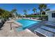 The fenced community pool is surrounded by palm trees and lounge chairs at 335 Sunset Lake Blvd, Venice, FL 34292