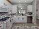 Bright kitchen features white cabinets, granite countertops, stainless steel appliances, and backsplash at 335 Sunset Lake Blvd, Venice, FL 34292