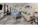 Comfortable living room with neutral colors, ceiling fan, screened lanai access, and modern furnishings at 335 Sunset Lake Blvd, Venice, FL 34292