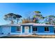 Cute blue house with a white door, garage, and landscaping at 3400 Rain Lily, Englewood, FL 34224