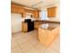 Bright kitchen with wood cabinets, granite counters and island at 3400 Rain Lily, Englewood, FL 34224